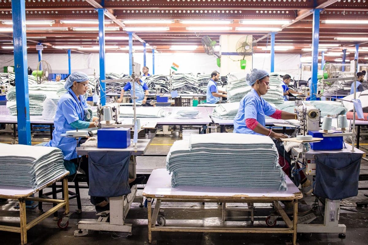 Garment factory workers operating sewing machines on the production floor